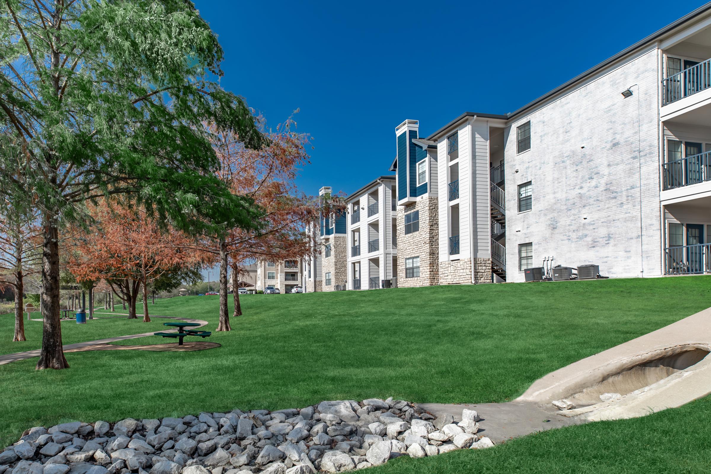 a large lawn in front of a brick building