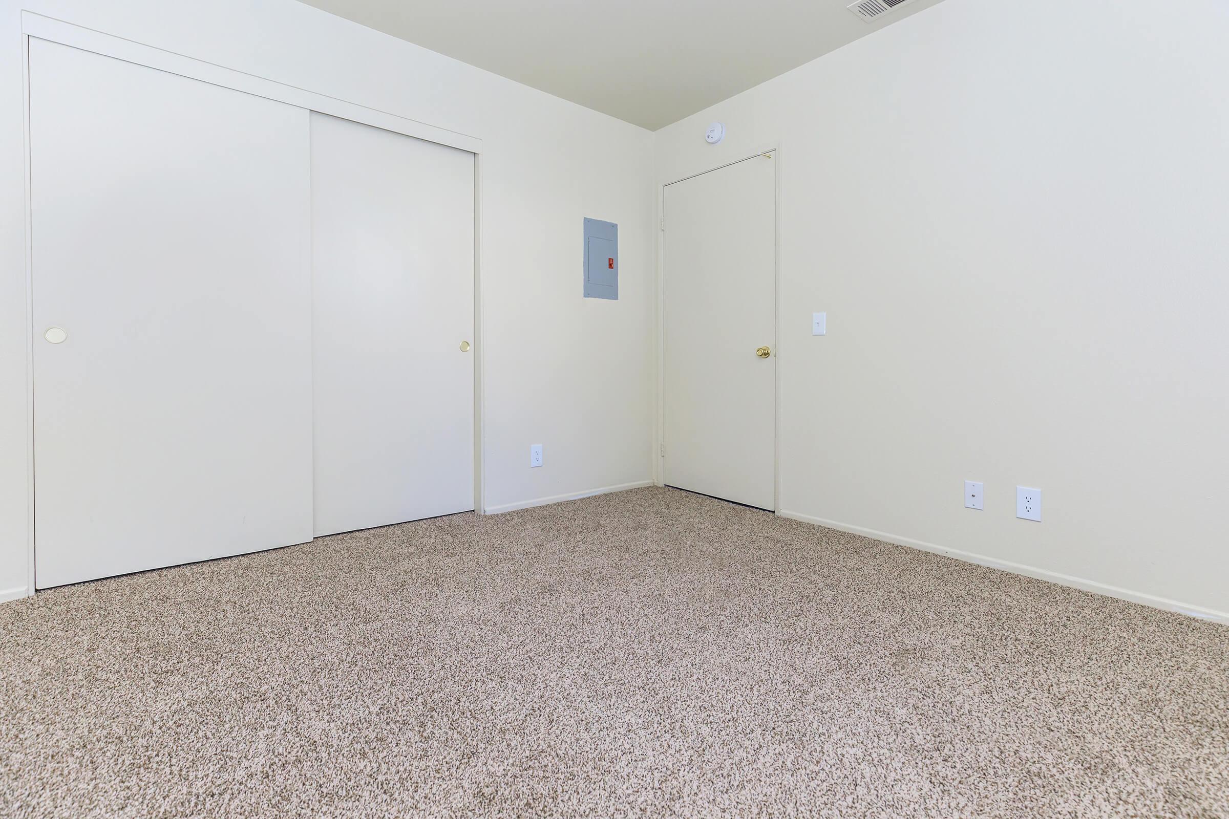 Carpeted bedroom with sliding closet doors