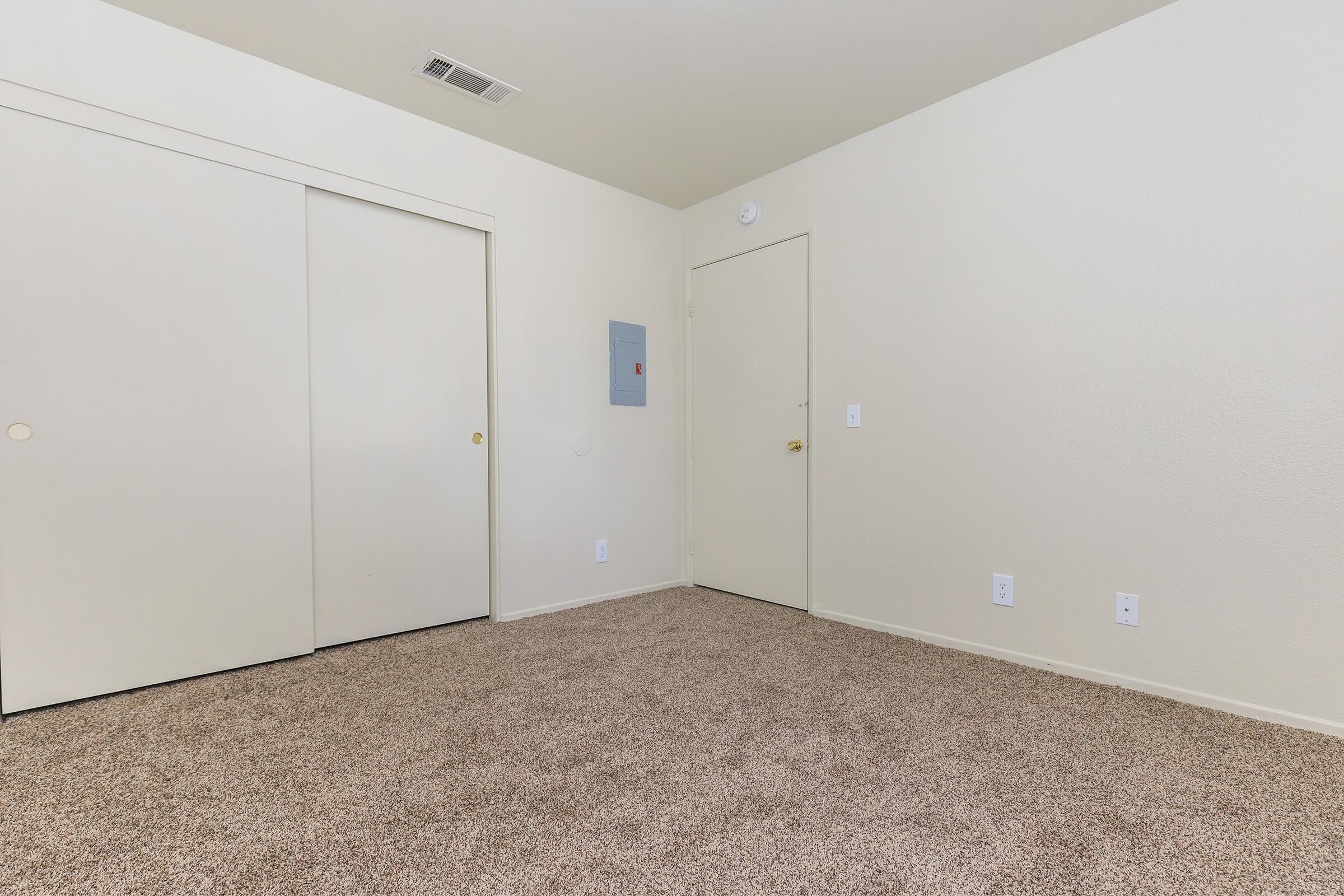 Unfurnished carpeted bedroom with closed sliding closet doors