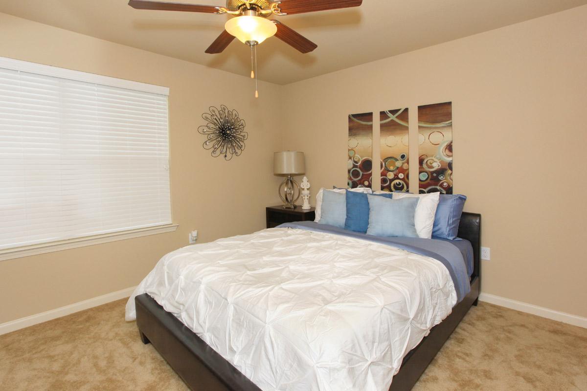 a bedroom with a bed and desk in a room