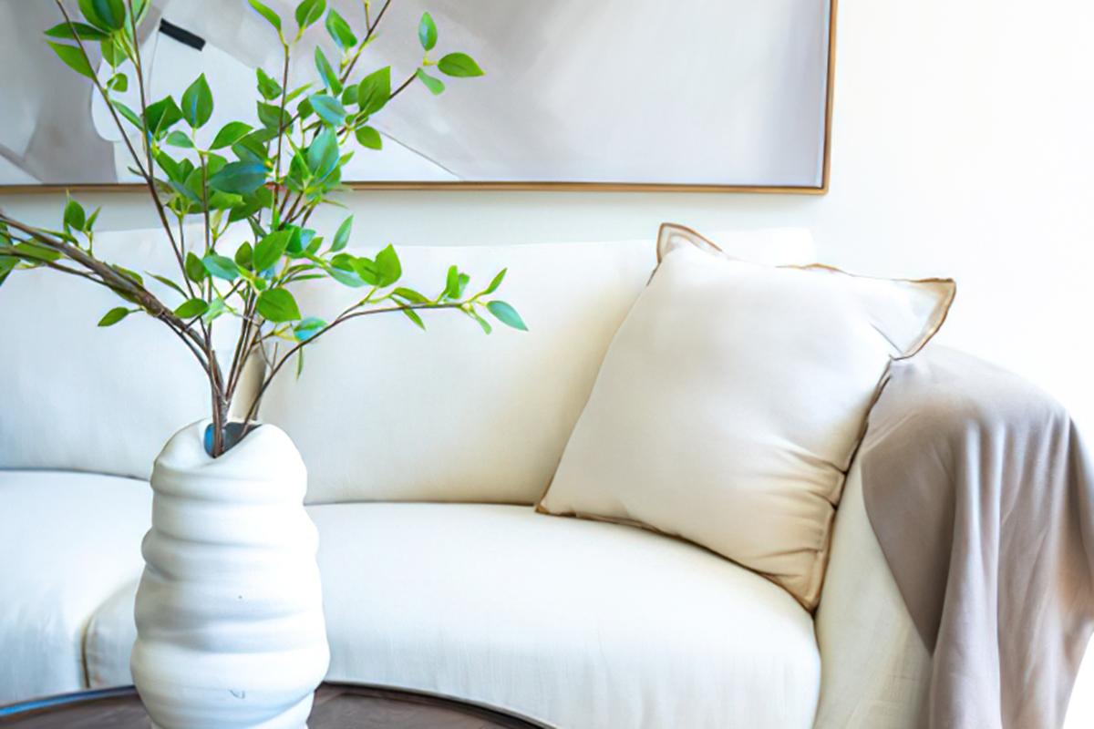 a living room filled with furniture and vase of flowers on a table