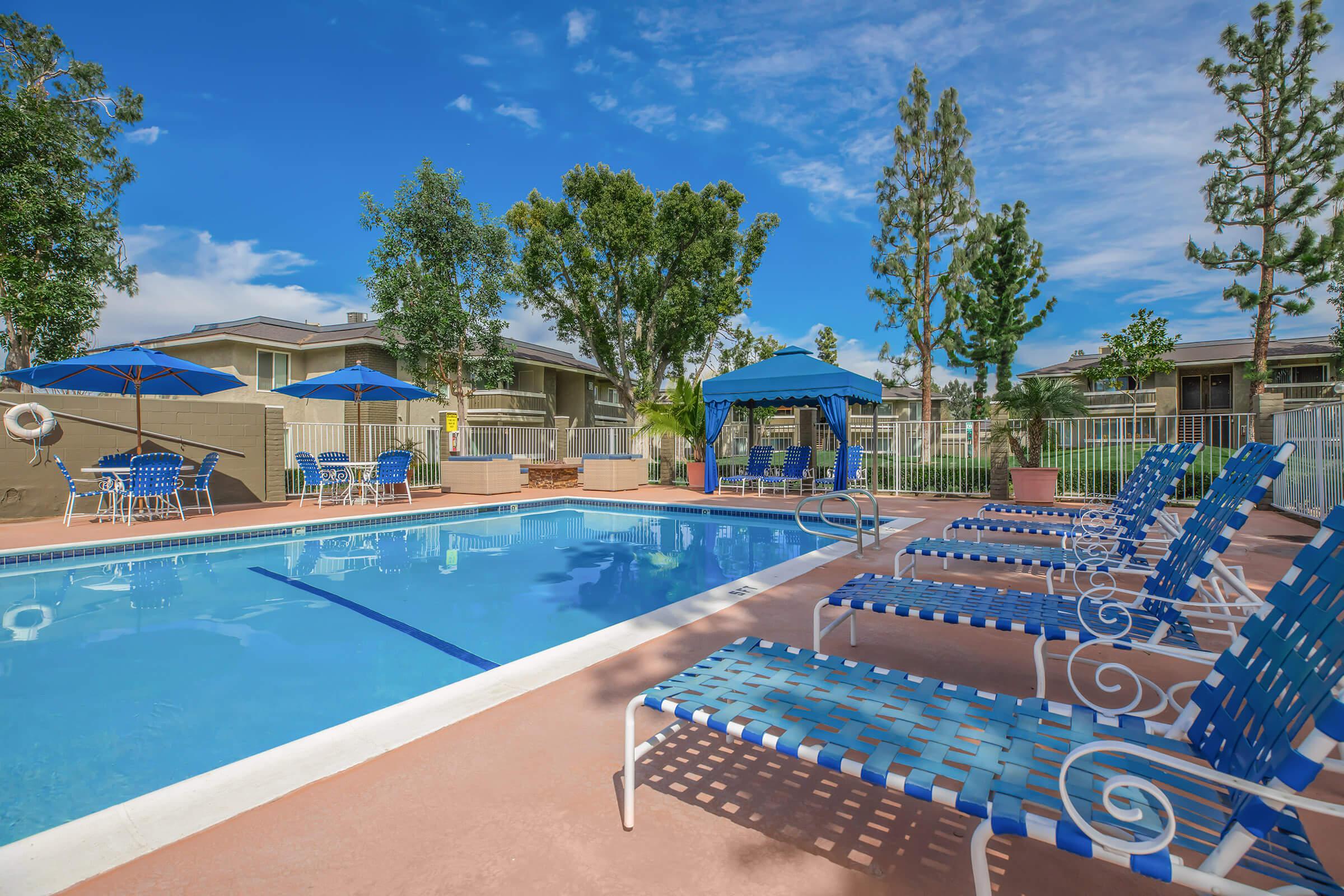 a group of lawn chairs sitting on top of a blue pool of water