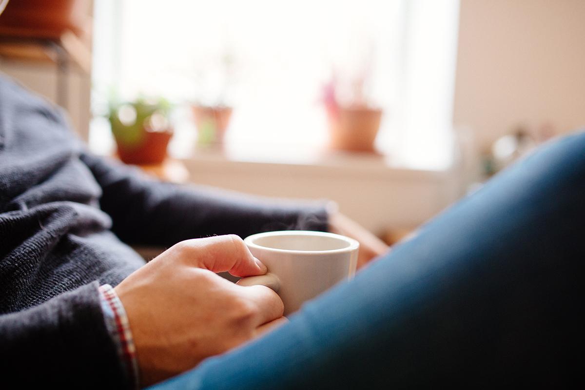 a close up of a person holding a cup of coffee