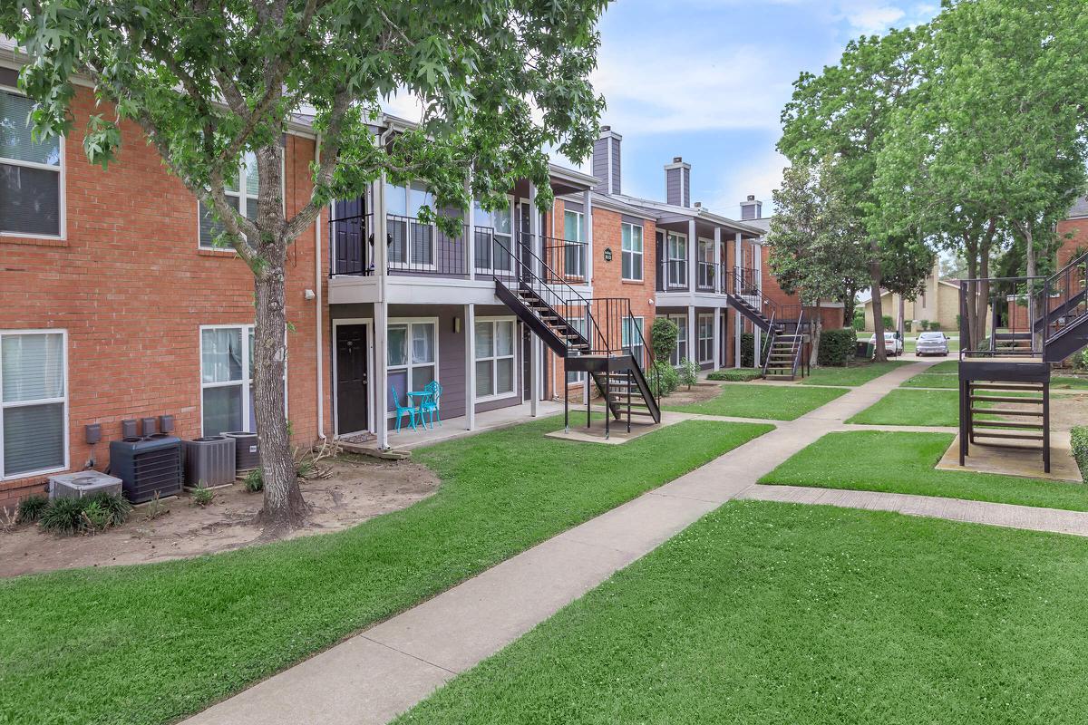 a large lawn in front of a brick building