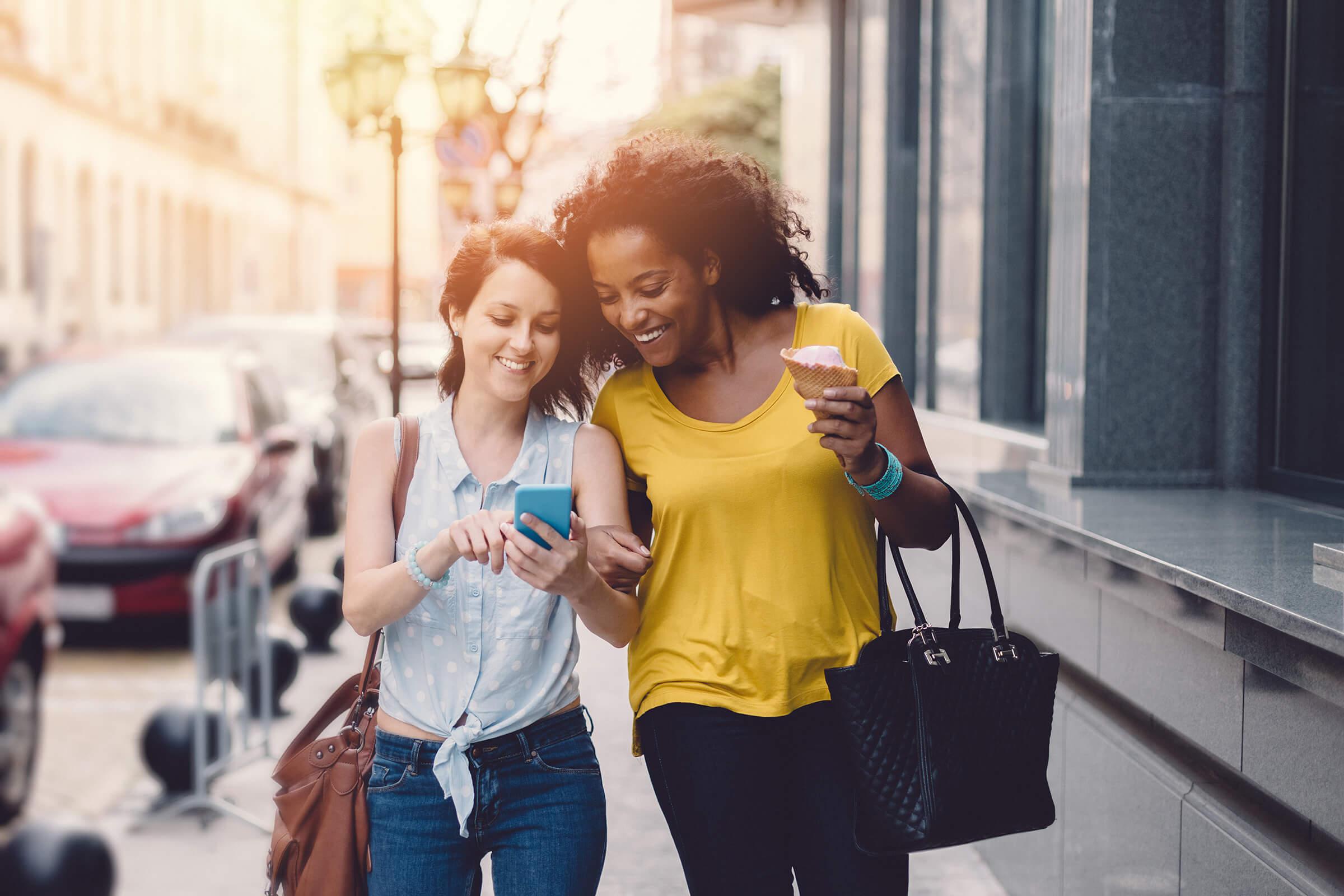 a woman walking down a street while talking on a cell phone