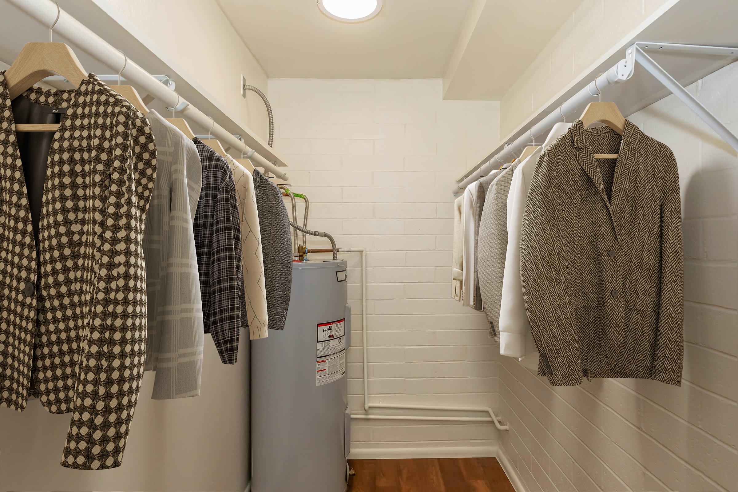 A well-organized closet featuring several stylish jackets hanging on a clothing rack. A water heater is visible in the corner, and the walls are painted white with a clean, modern aesthetic. The flooring is wooden, contributing to a warm and inviting atmosphere.