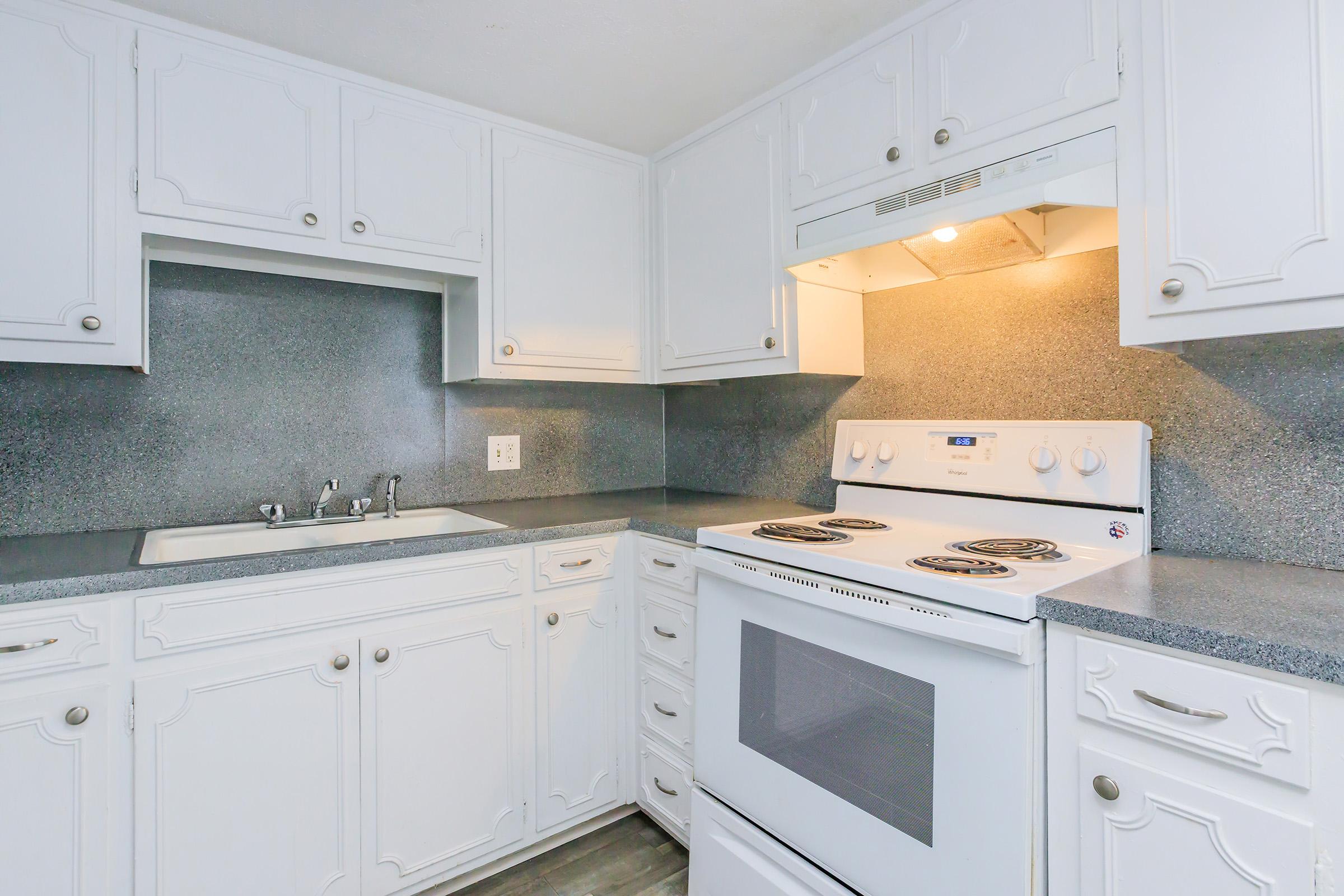 a stove top oven sitting inside of a kitchen