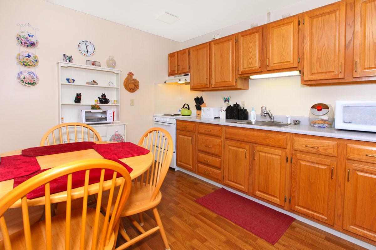 a kitchen with wooden cabinets and a dining table