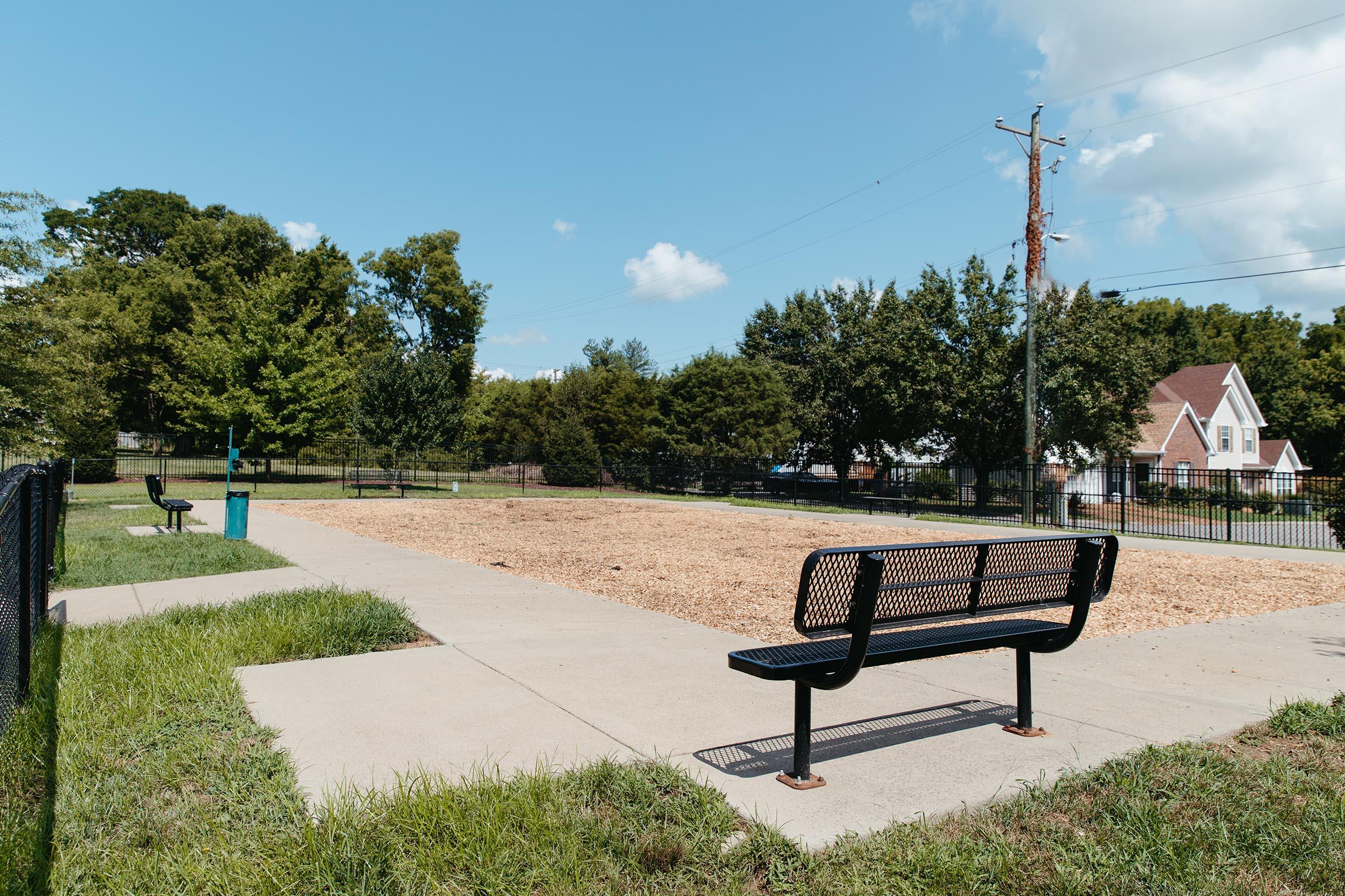 an empty park bench next to a body of water