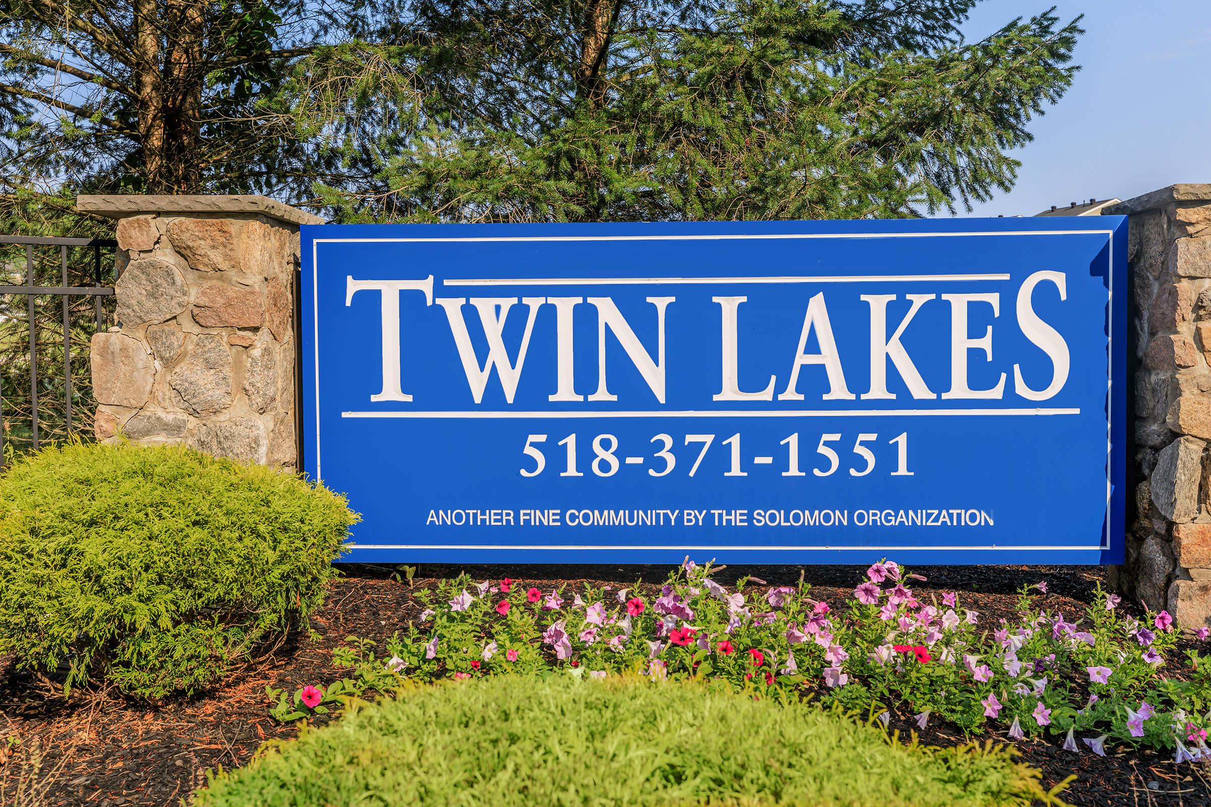 a sign with blue and green bushes