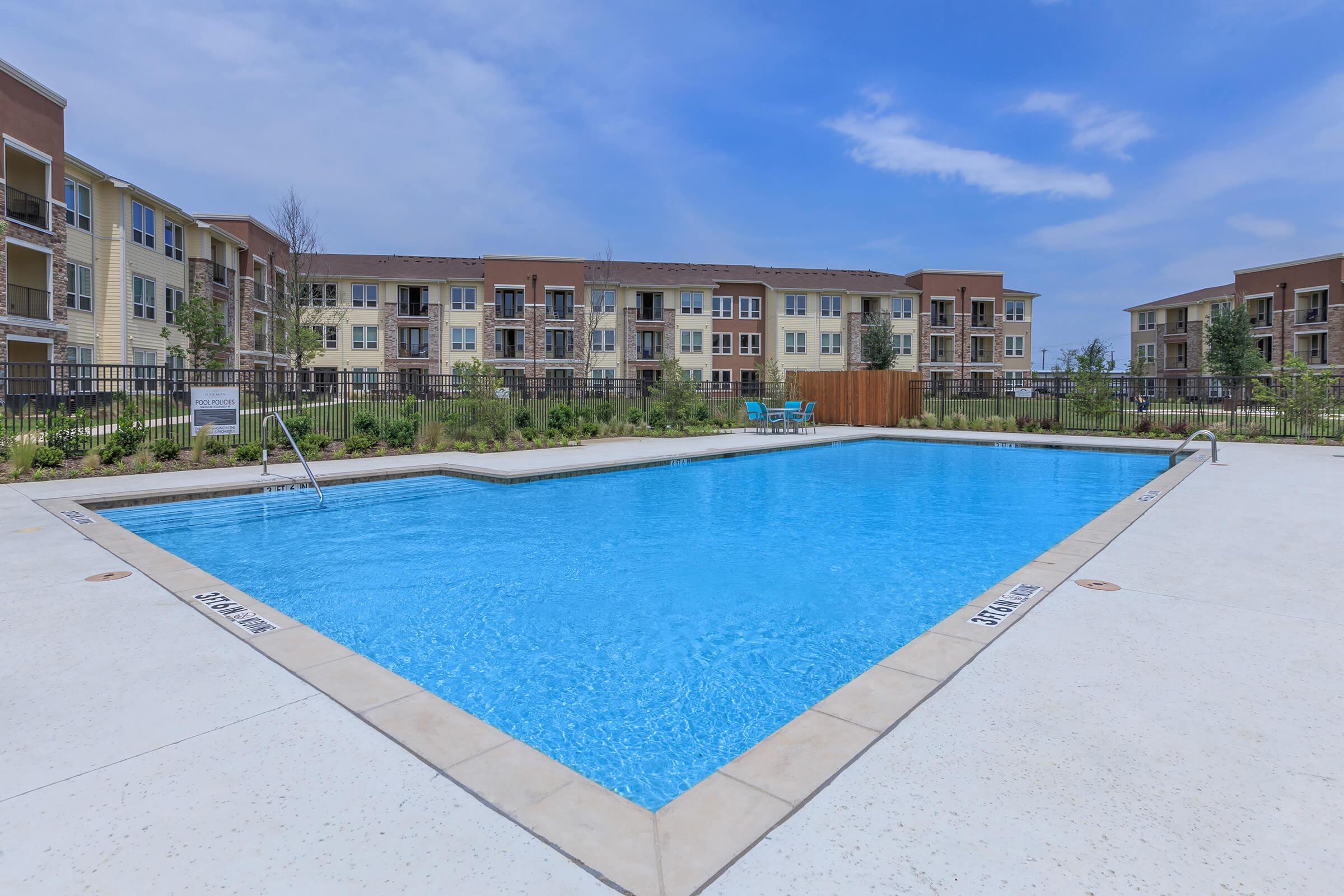 a building with a pool in front of a body of water