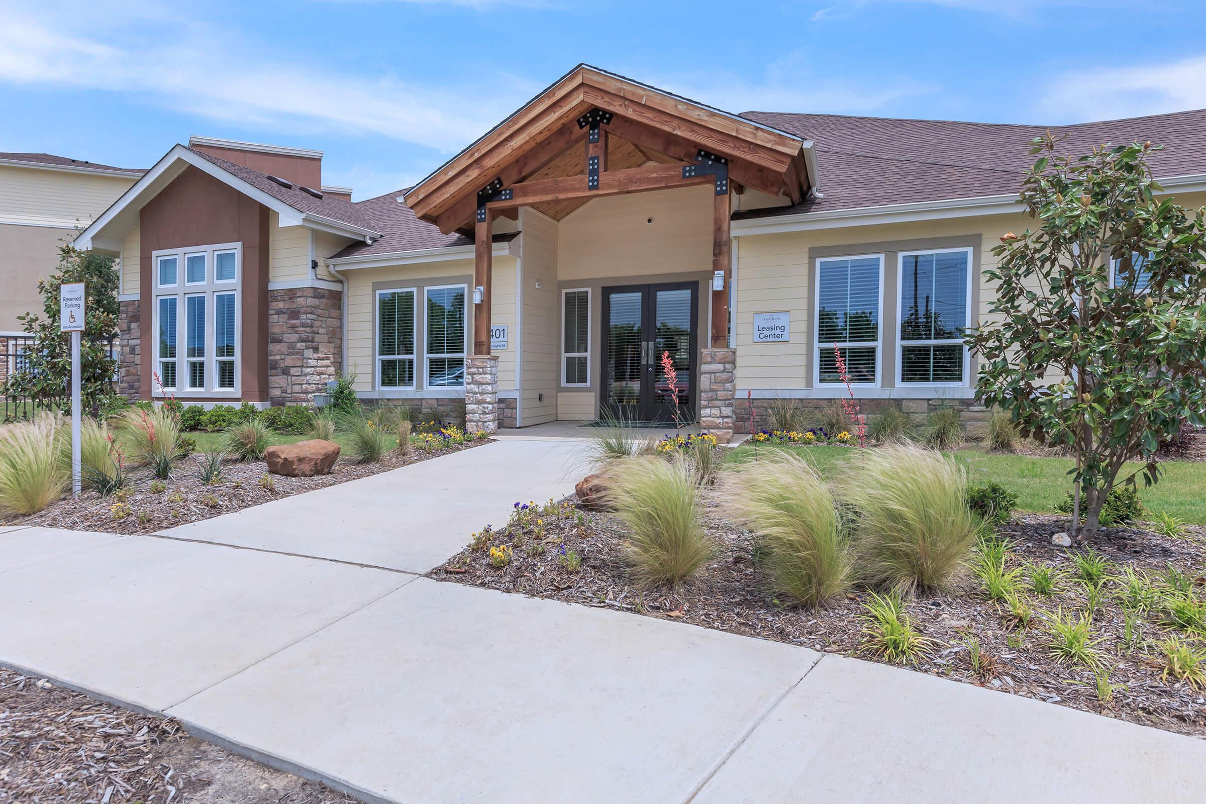 a large brick building with grass in front of a house