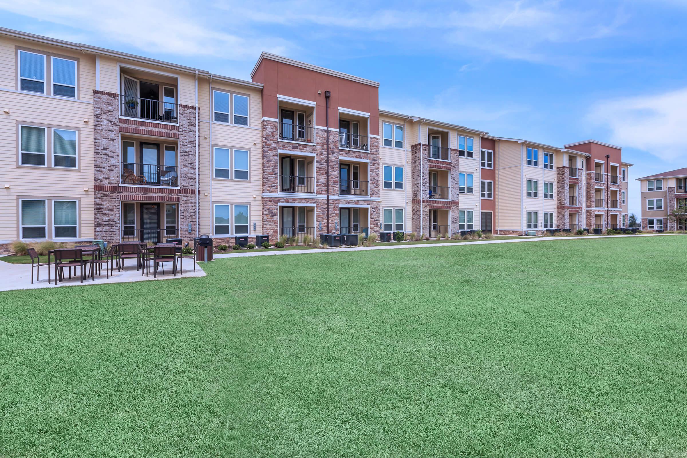 a large green field in front of a building