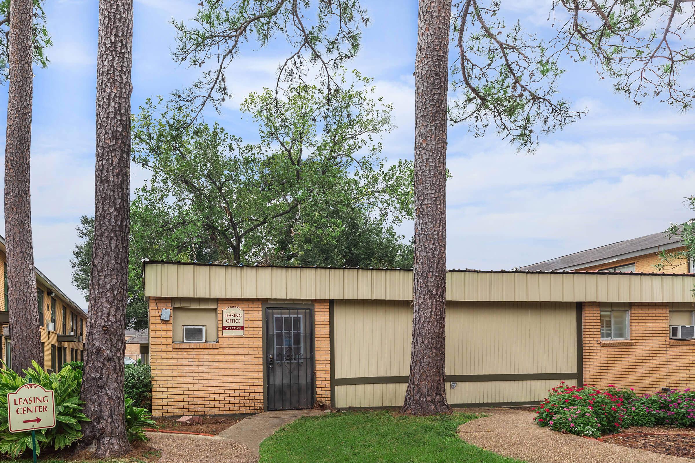 a house with bushes in front of a brick building