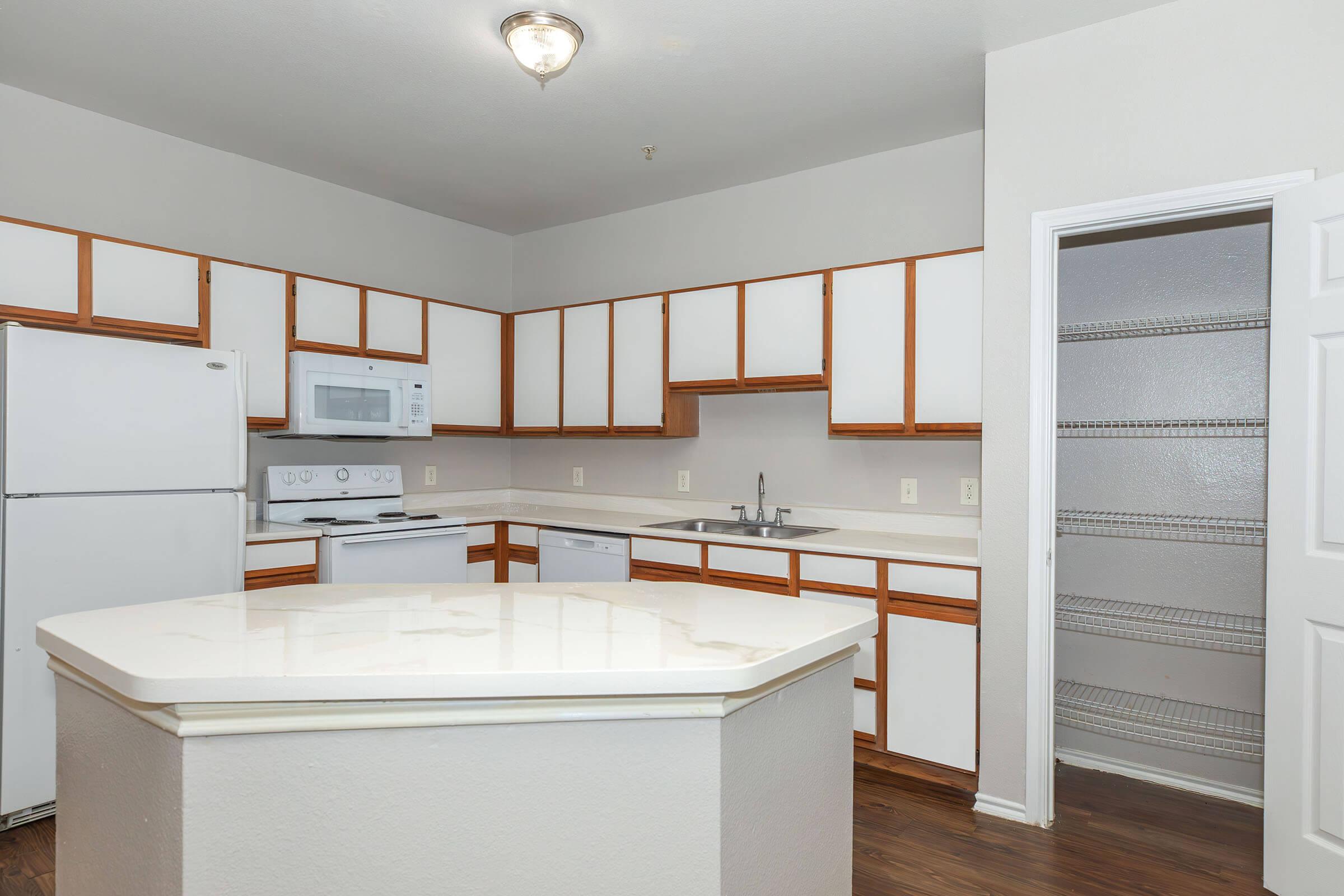 a kitchen with a sink and a mirror in a room