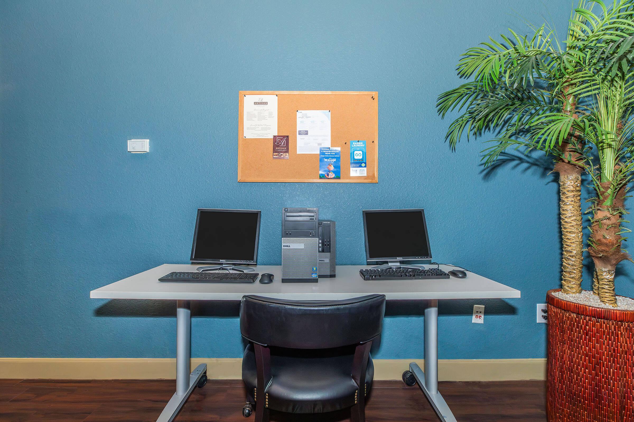 a desk with a laptop computer sitting on top of a wooden chair