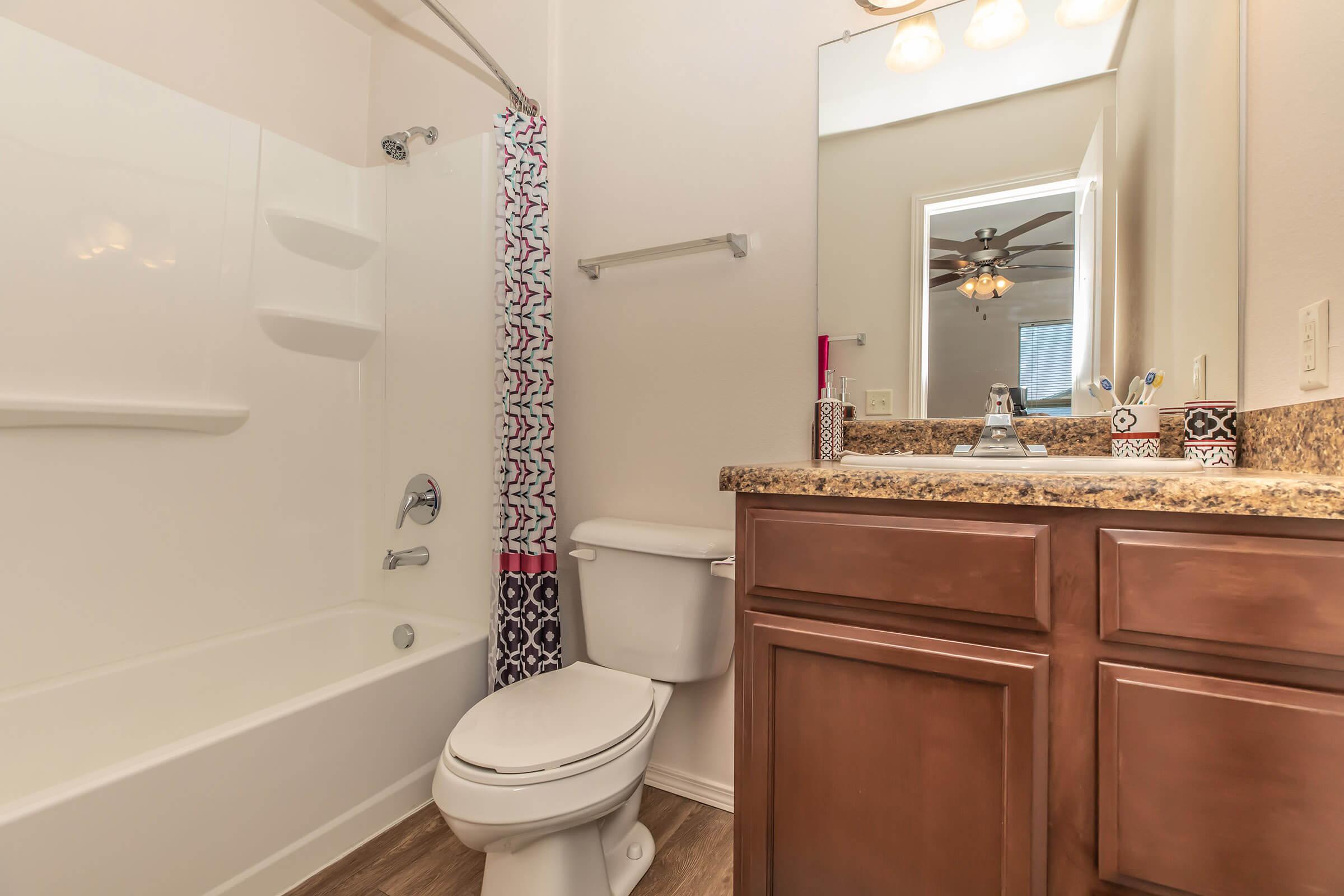 a white sink sitting under a mirror