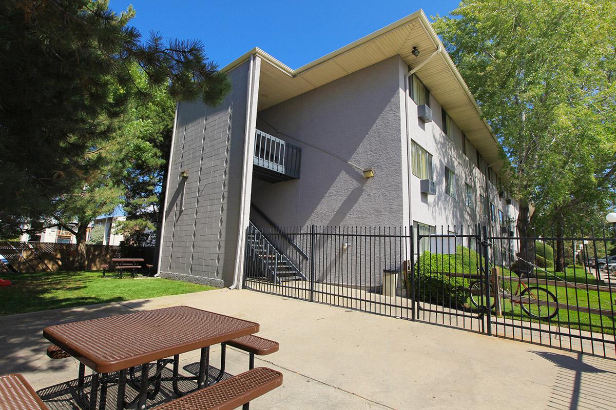 an empty park bench next to a building