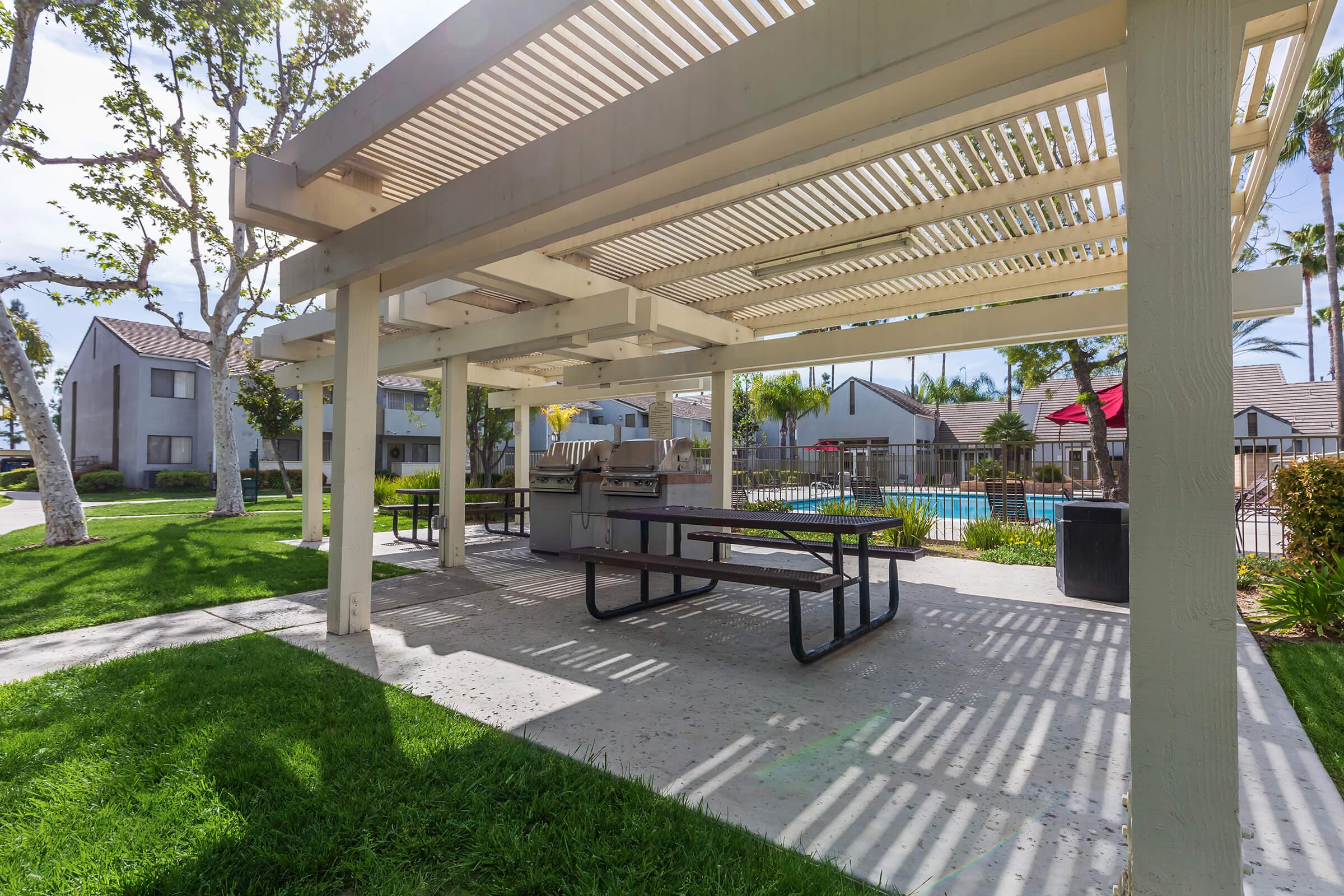Picnic tables and barbecues under a pergola