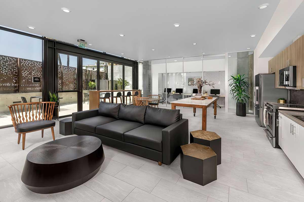 A modern interior space featuring a black sofa, wooden chairs, and a dining table