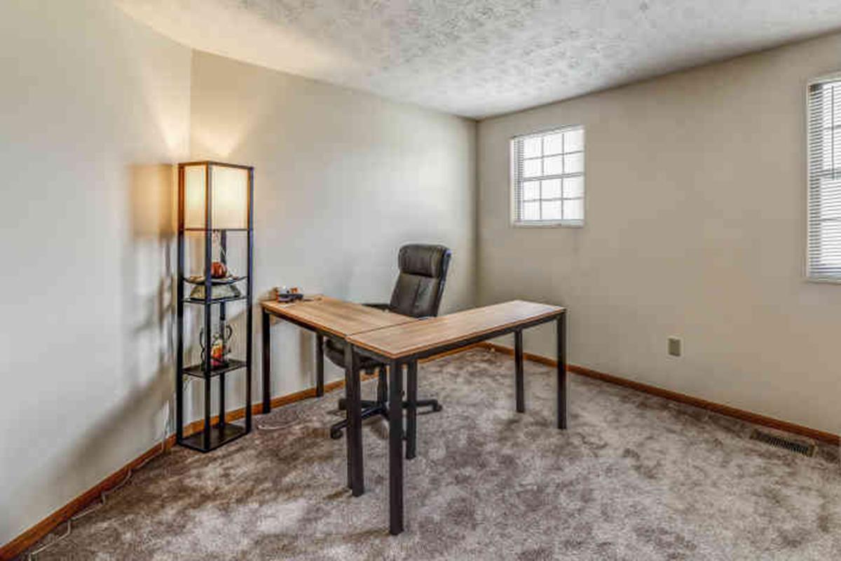 a bedroom with a bed and desk in a room