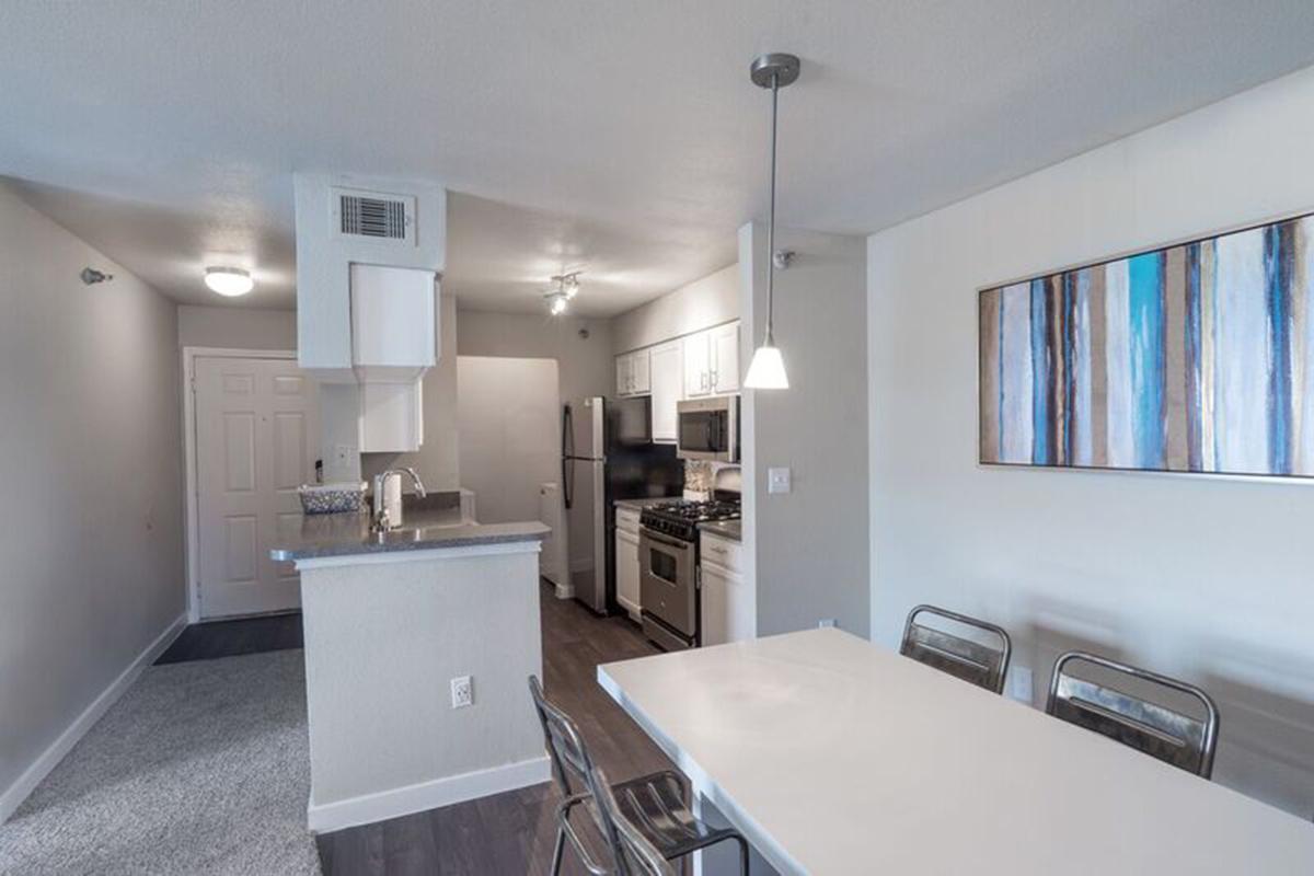 a kitchen with a sink and a mirror in a room
