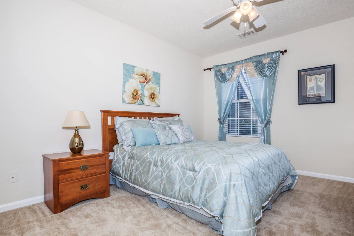 a bedroom with a bed and desk in a room