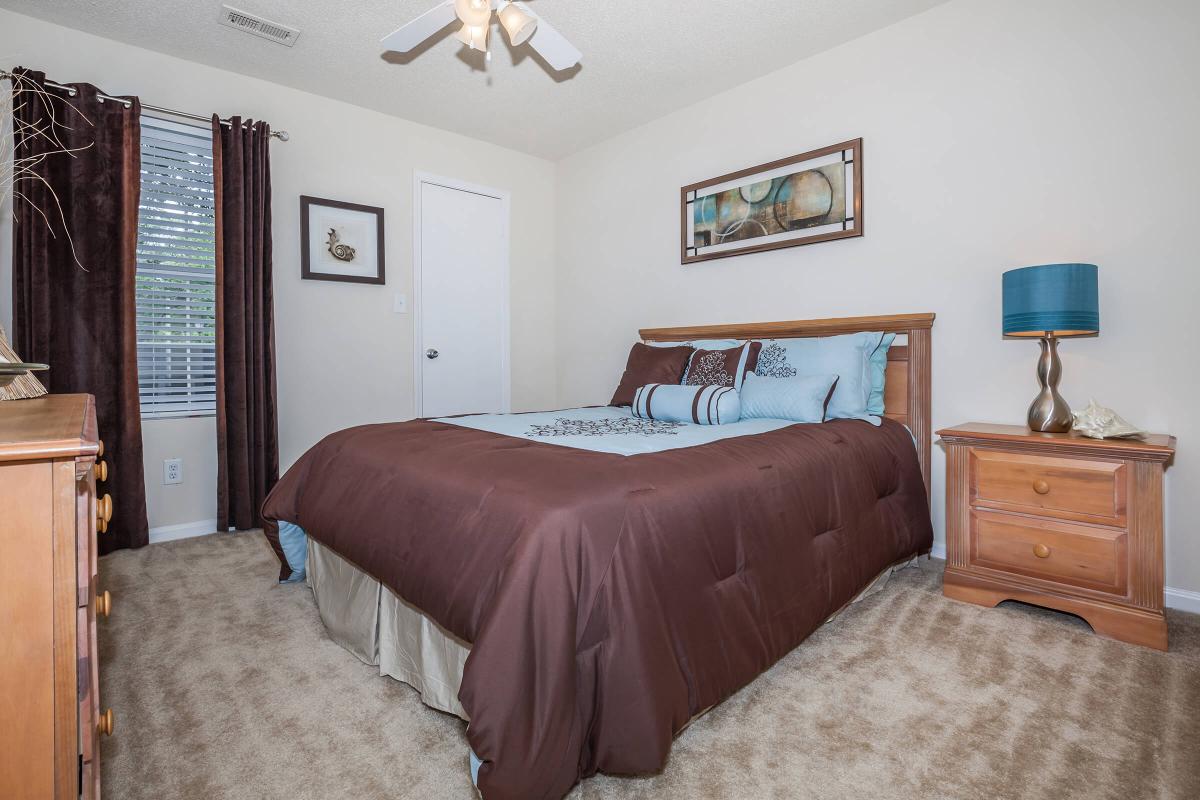 a bedroom with a bed and desk in a room