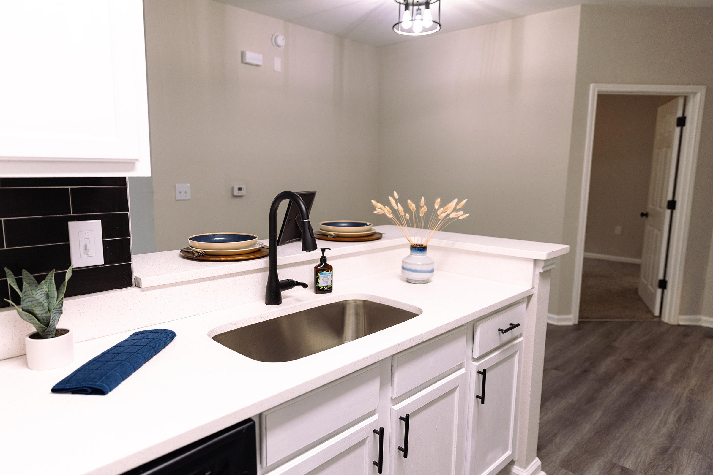 a kitchen with a sink and a mirror