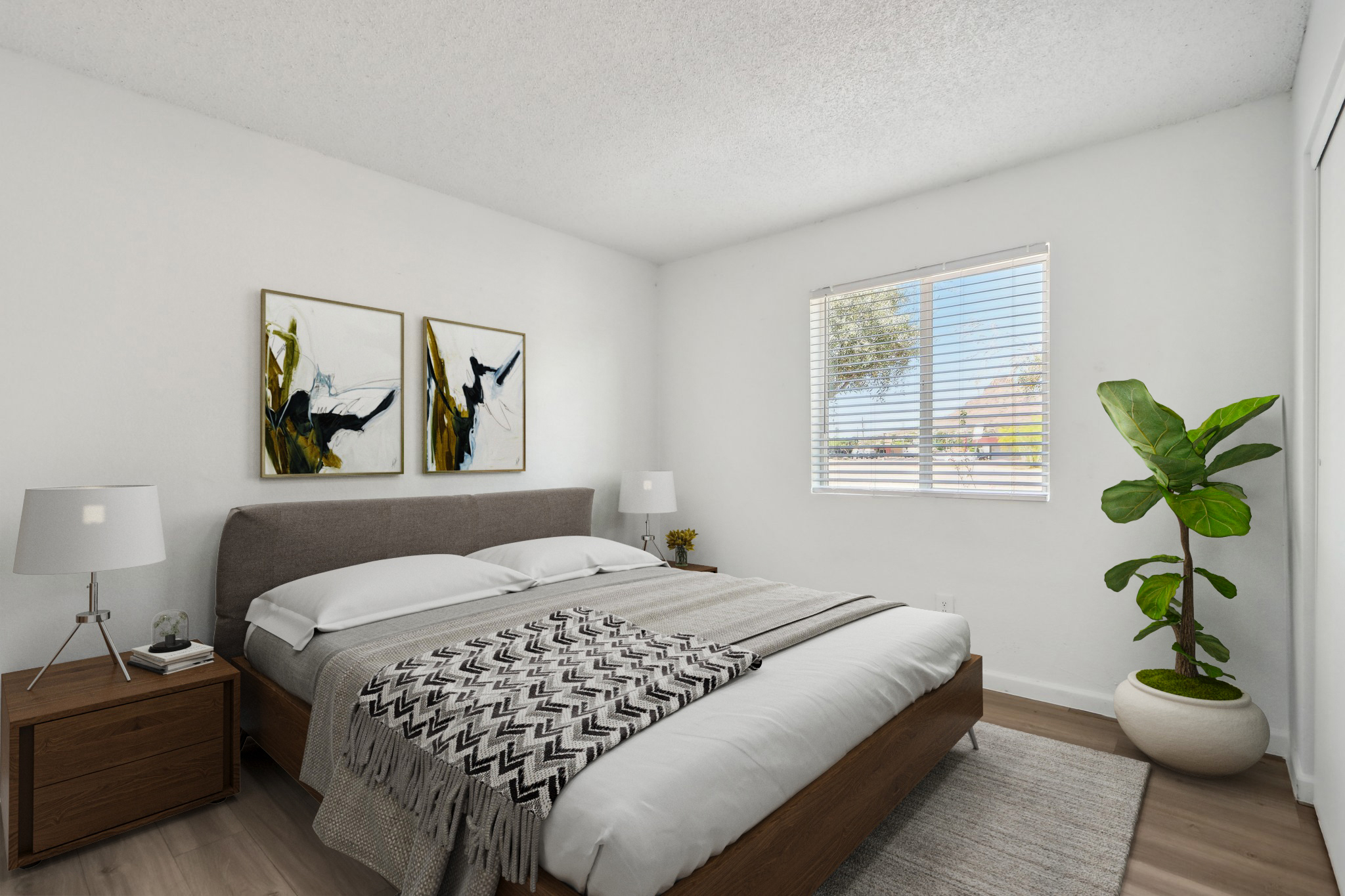 A cozy bedroom featuring a queen-sized bed with white bedding, a textured throw blanket, and two aesthetic art pieces on the wall. There are bedside lamps on wooden nightstands, and a large window with blinds lets in natural light. A potted plant adds a touch of greenery to the space.