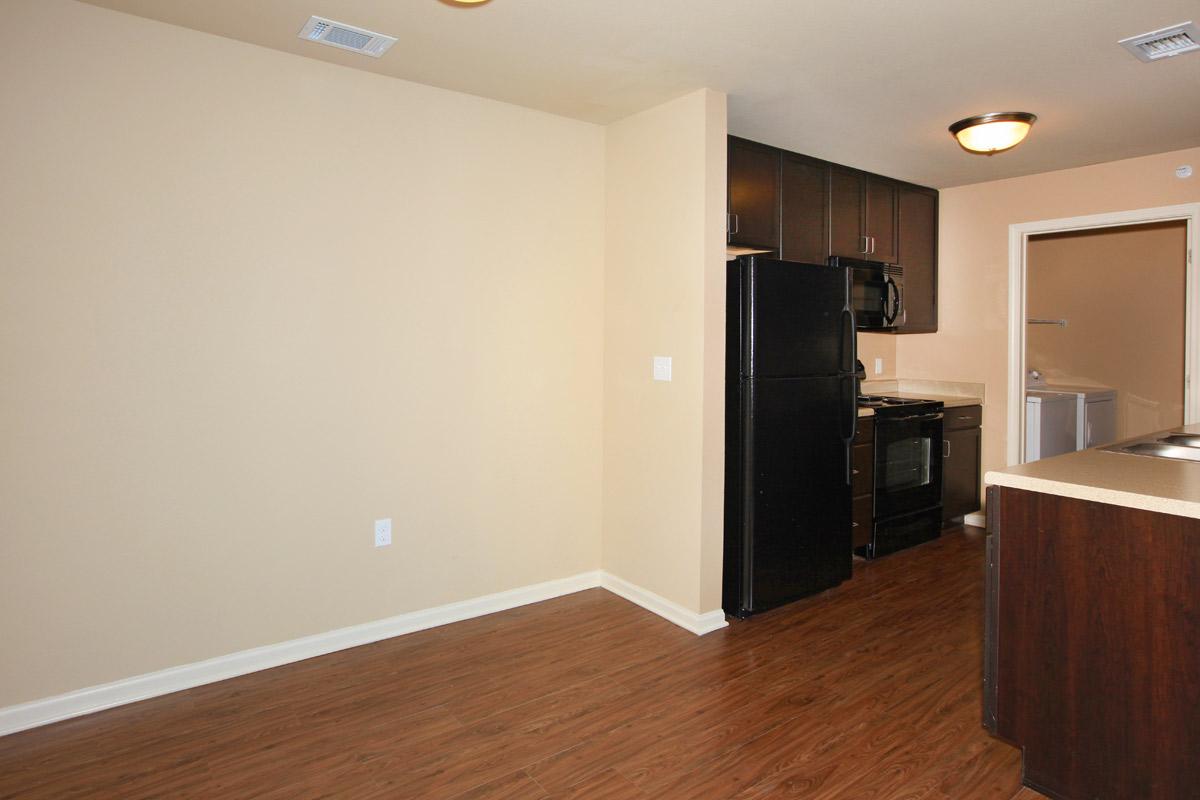 a kitchen with wooden cabinets and a wood floor