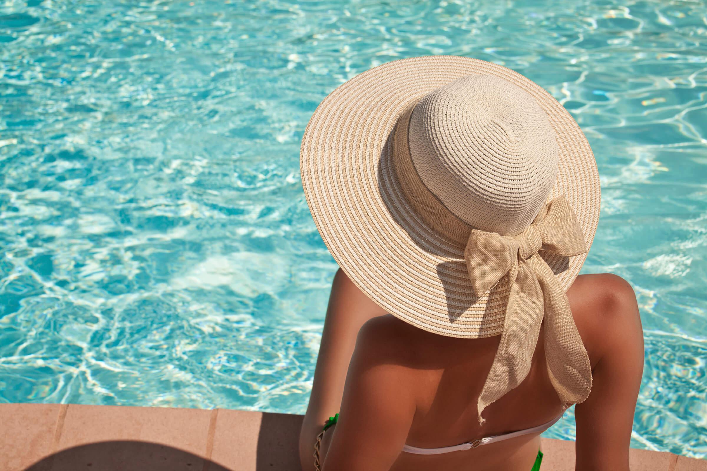 Young woman sitting on the ledge of the pool iStock_000047227562_Large.jpg