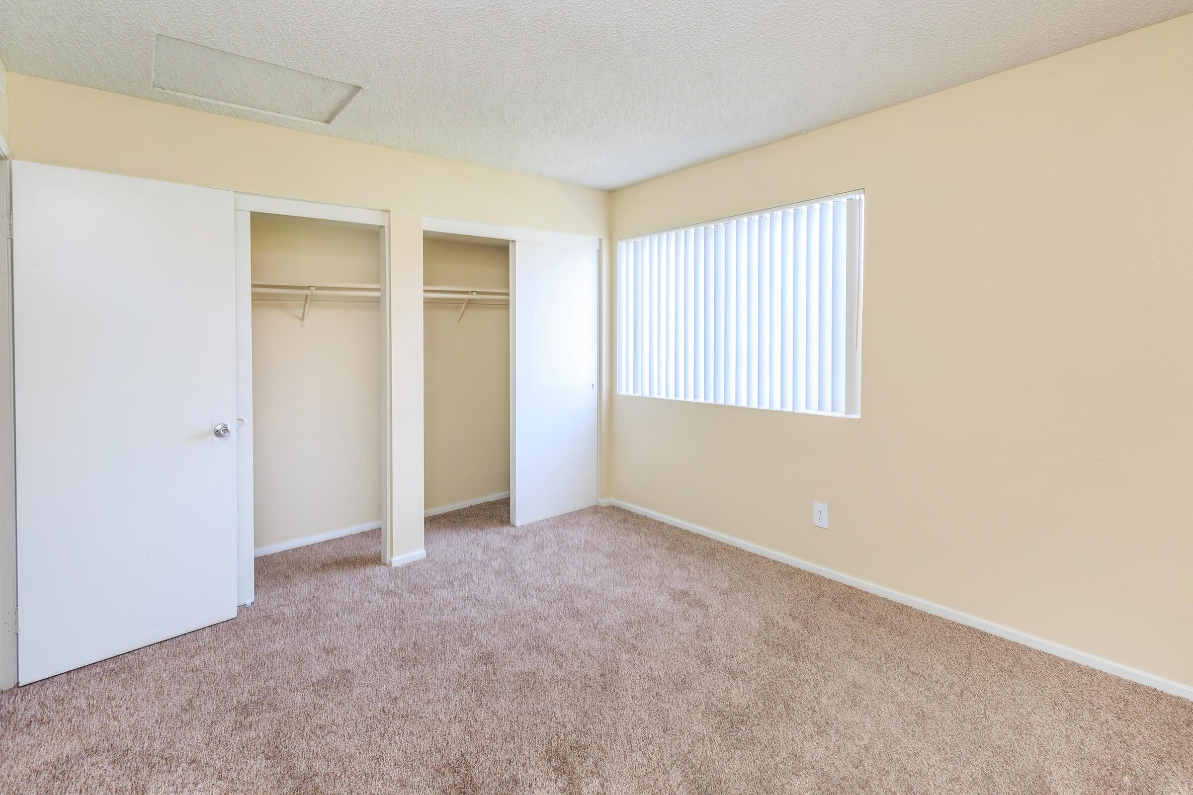 Vacant bedroom with open closet doors