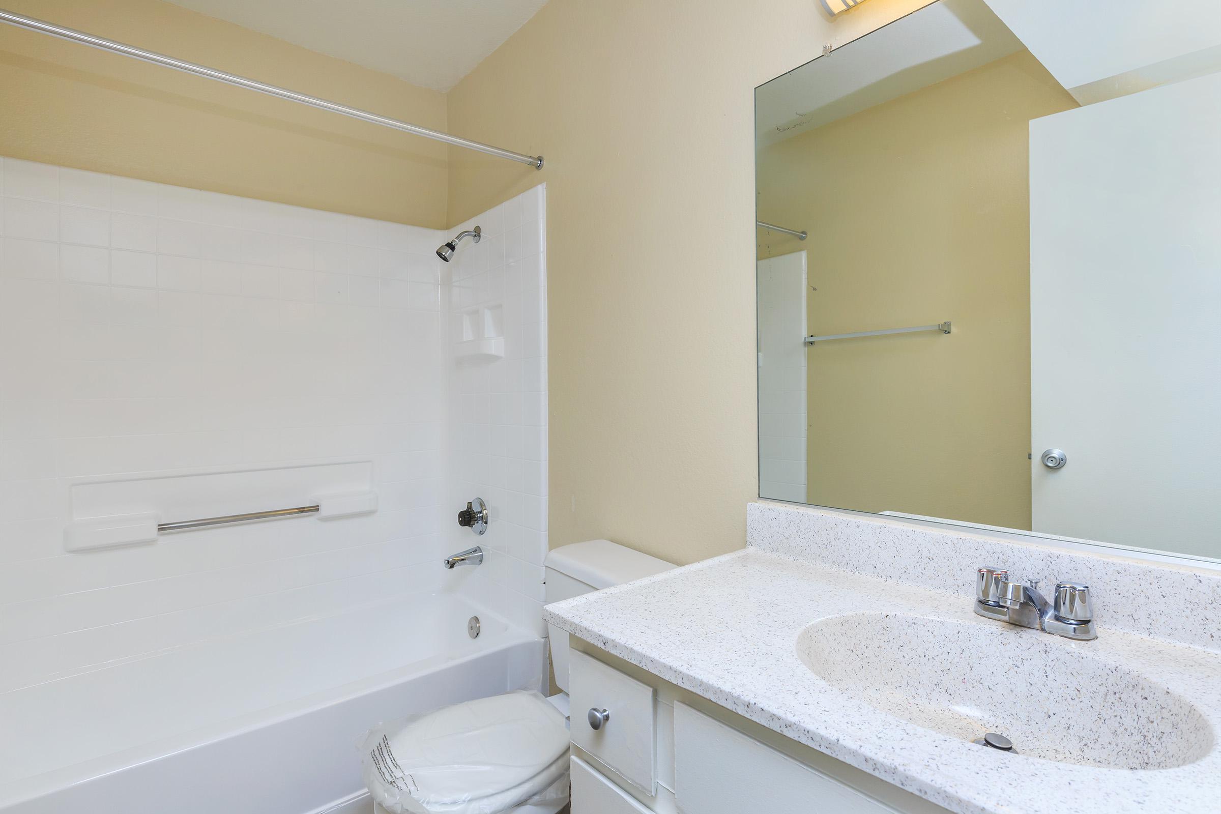 Vacant bathroom with white cabinets