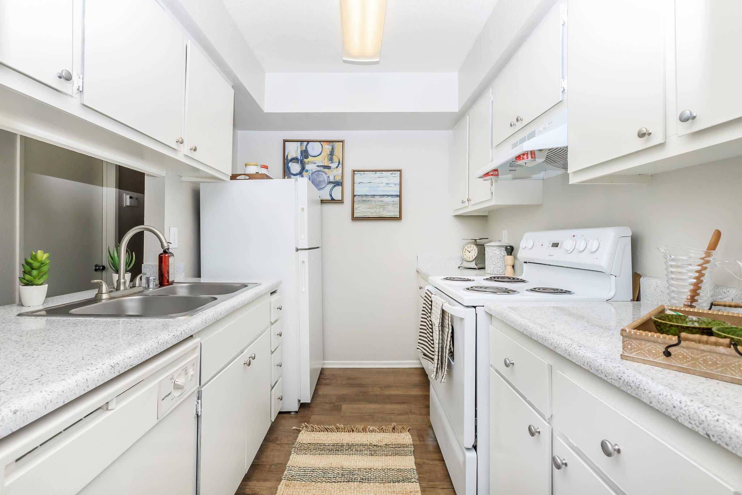 Furnished kitchen with white appliances and cabinets