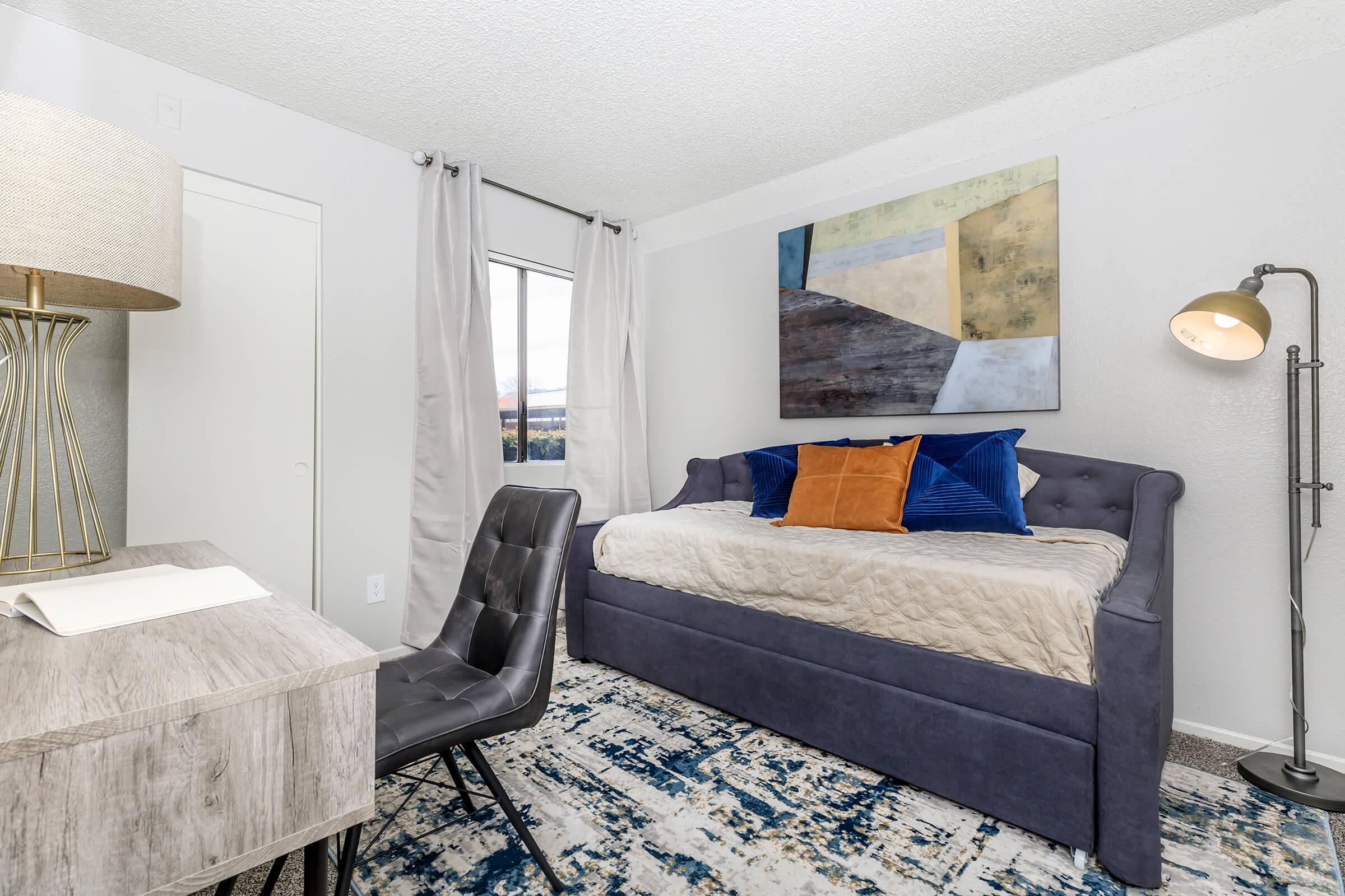 Furnished bedroom with blue and orange accent pillows