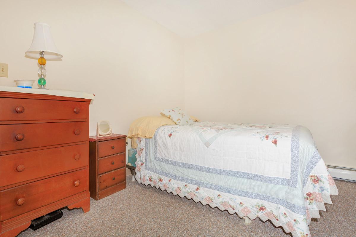 a bedroom with a bed and desk in a small room