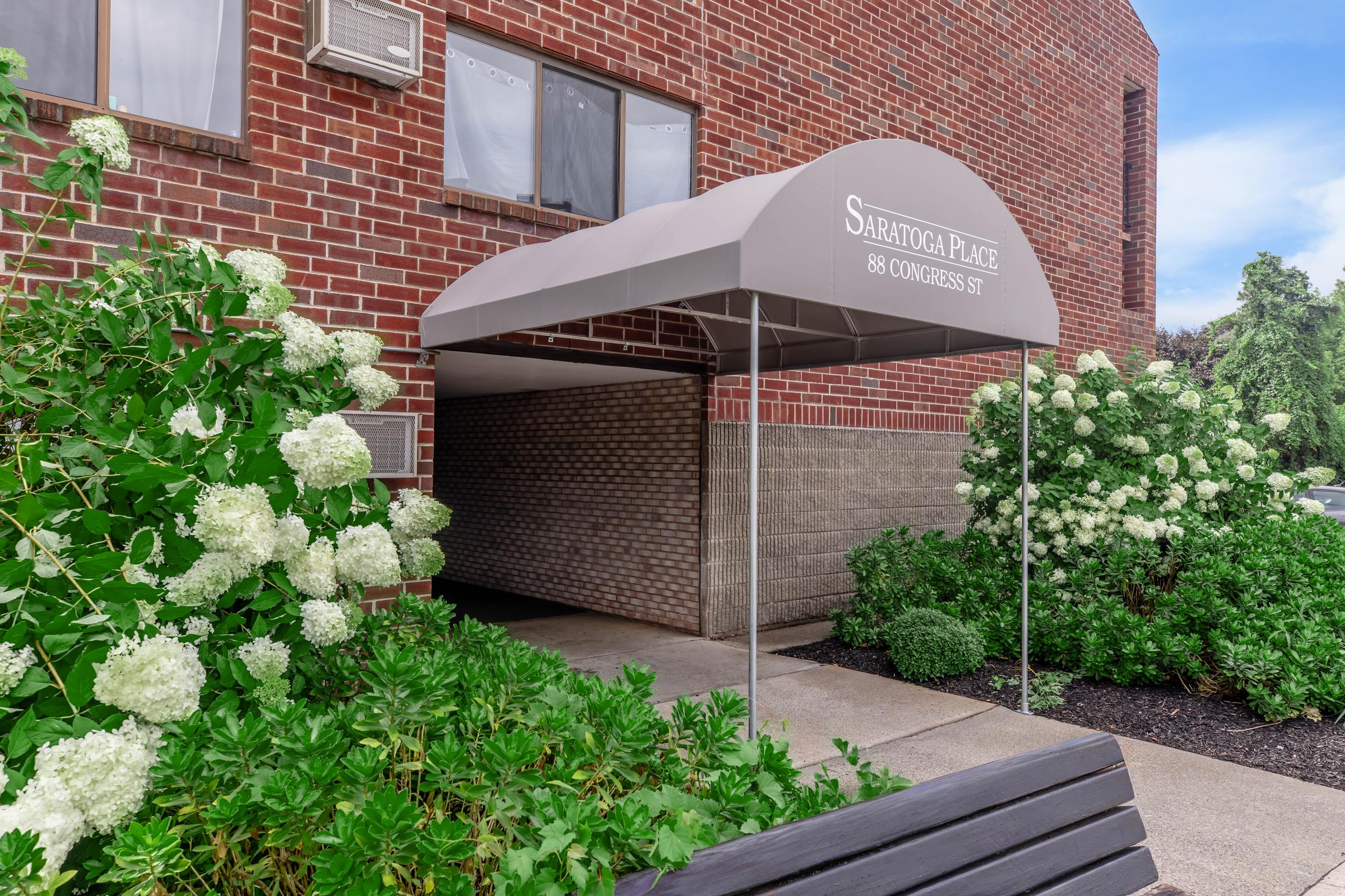 a close up of a flower garden in front of a brick building