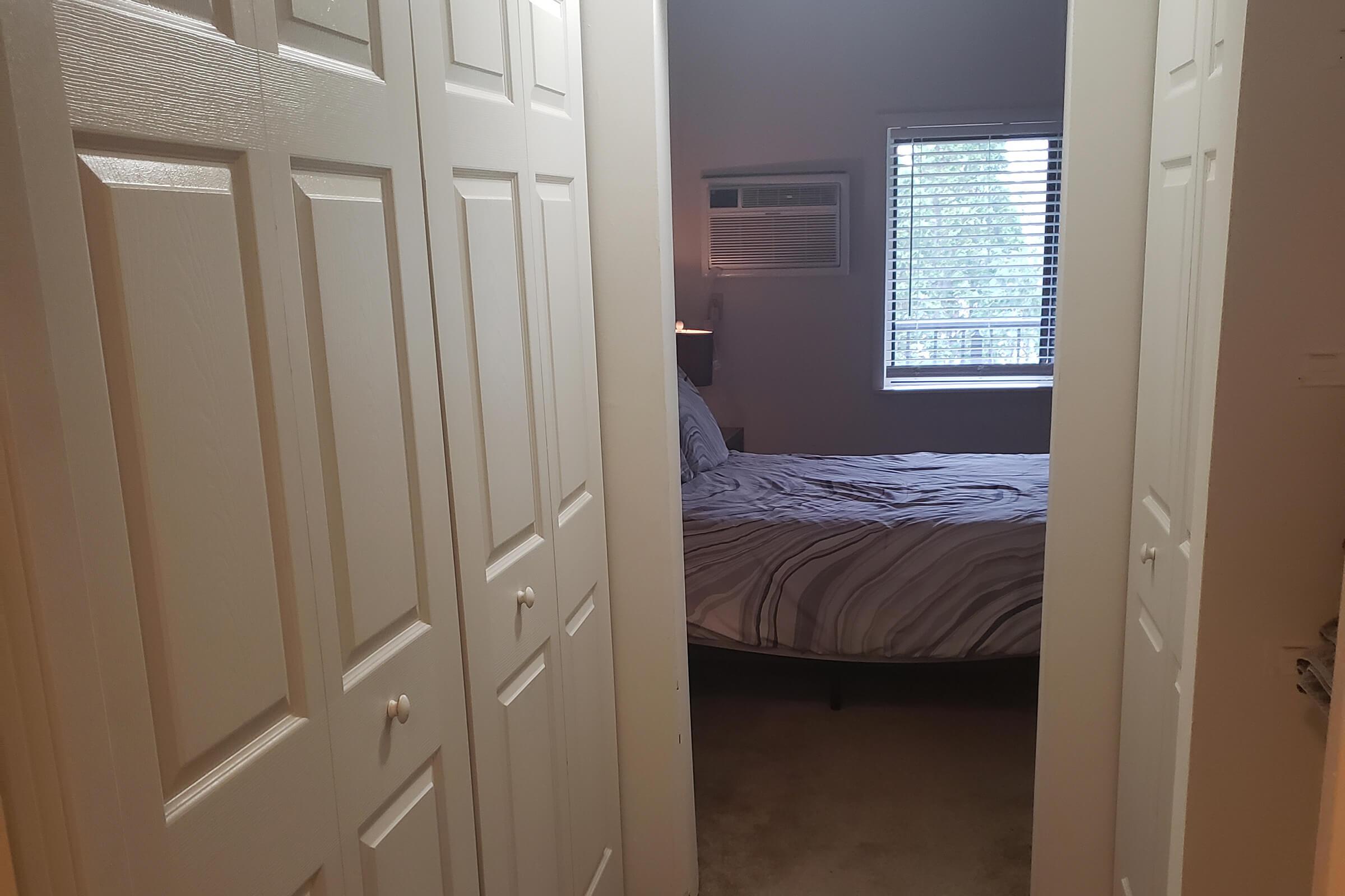 a bedroom with a bed a dresser and a door