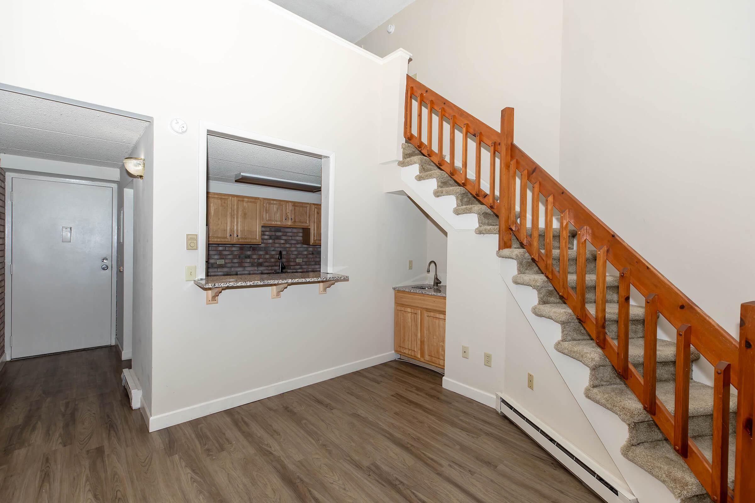 a room with wood floors and wooden cabinets