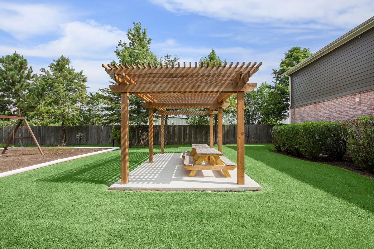 a couple of lawn chairs sitting on top of a grass covered field