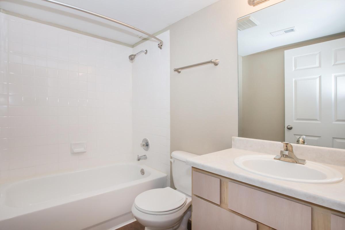 a white sink sitting next to a shower