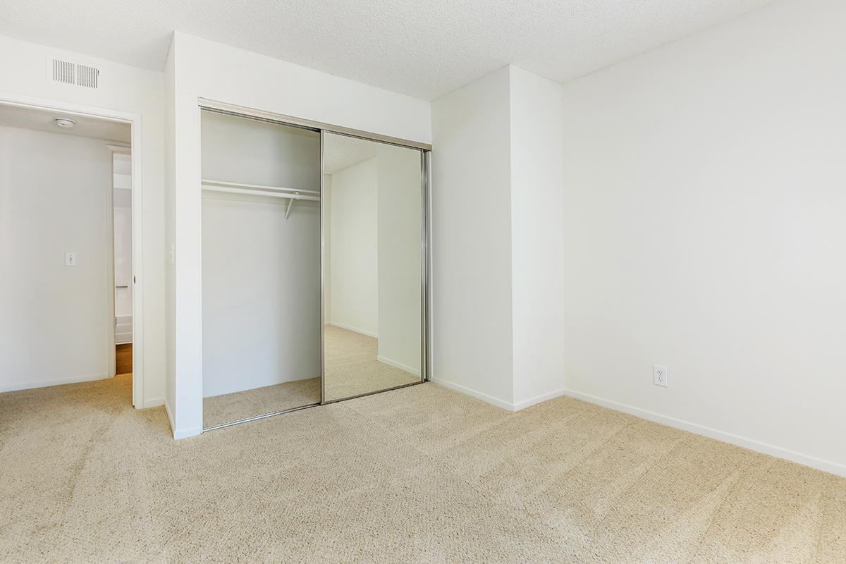 Bedroom with open sliding mirror glass closet doors