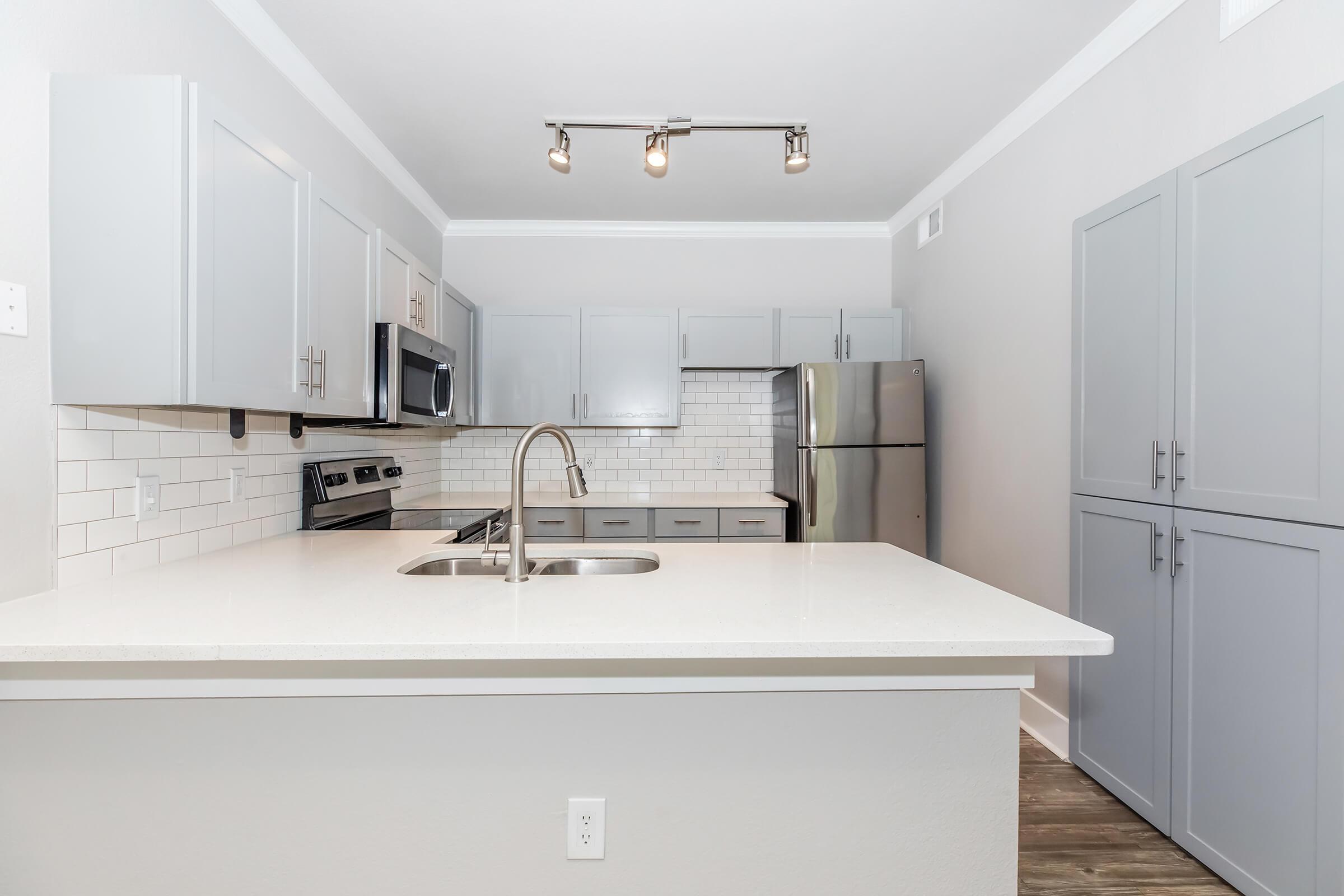 a kitchen with a sink and a mirror