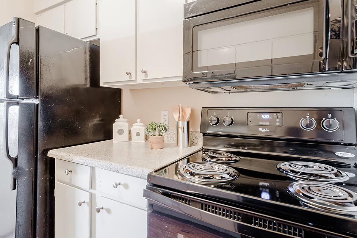 a stove top oven sitting inside of a kitchen with stainless steel appliances