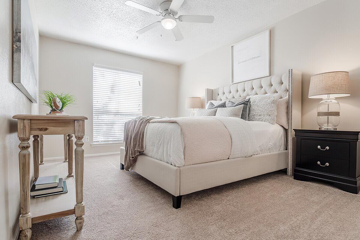 a bedroom with a bed and desk in a room