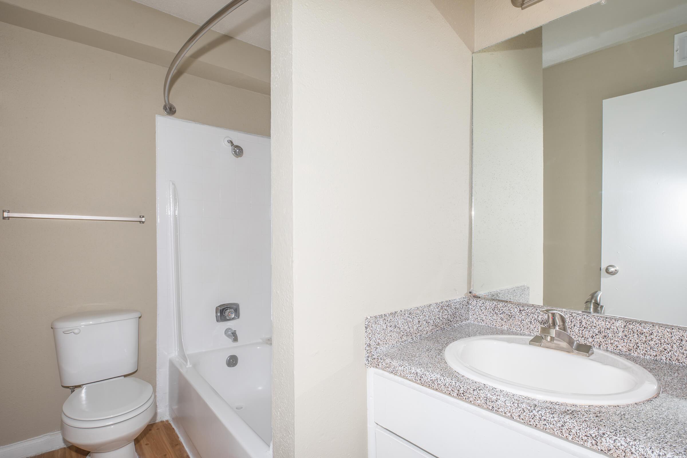 a white sink sitting under a mirror