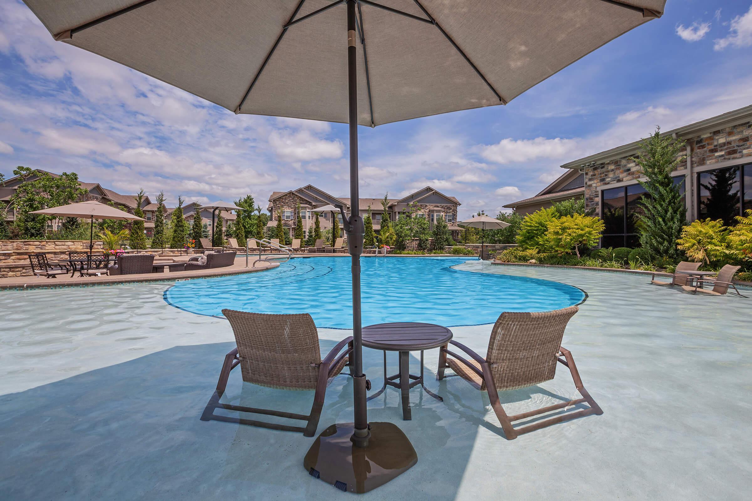 a couple of lawn chairs sitting next to a pool of water