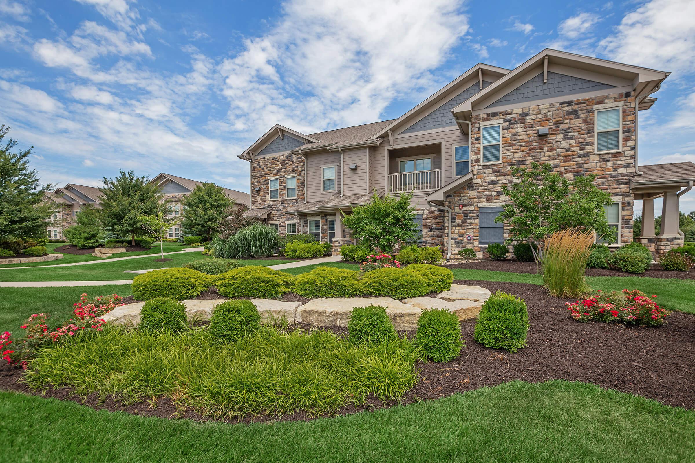 a close up of a flower garden in front of a house