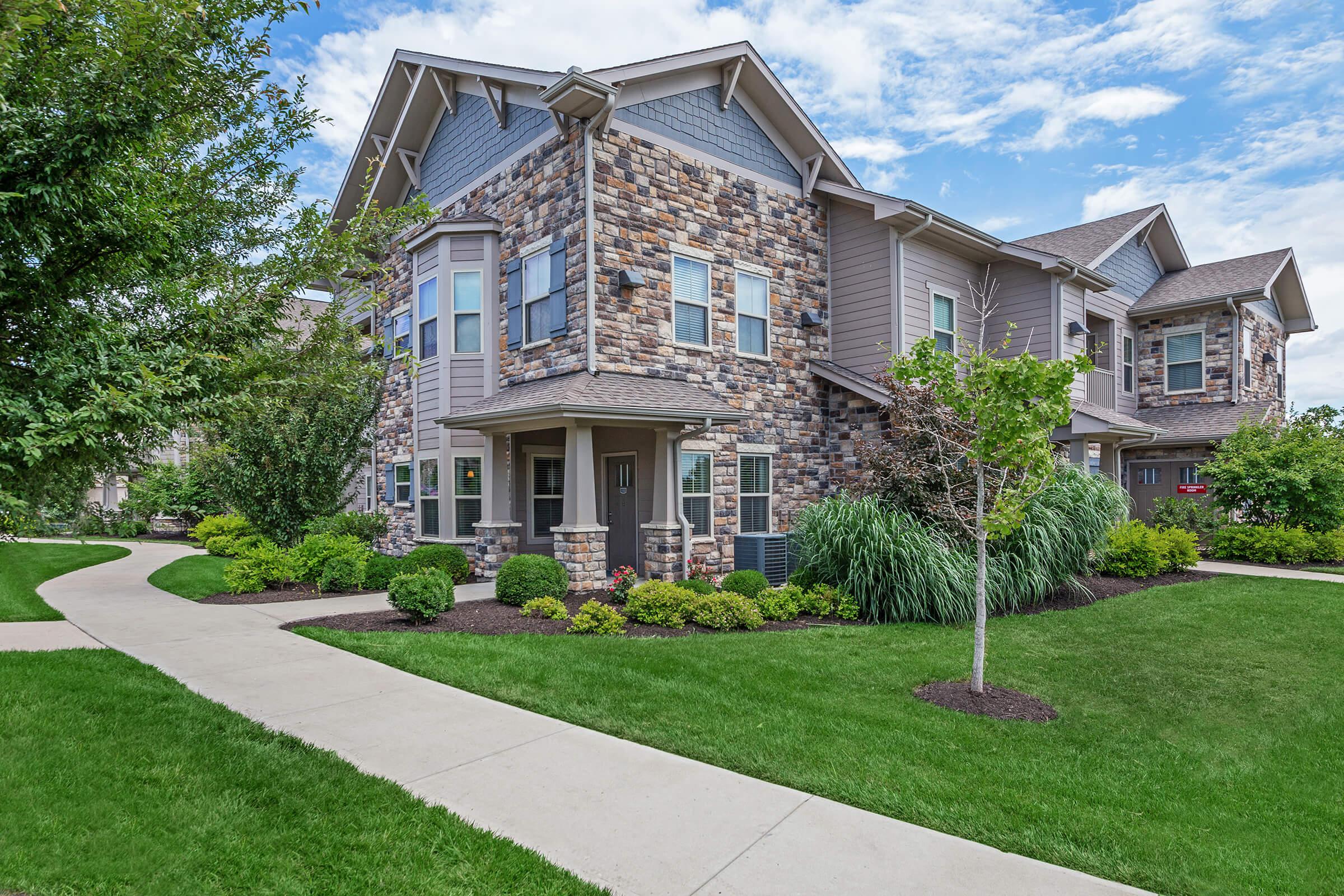 a large brick building with grass in front of a house